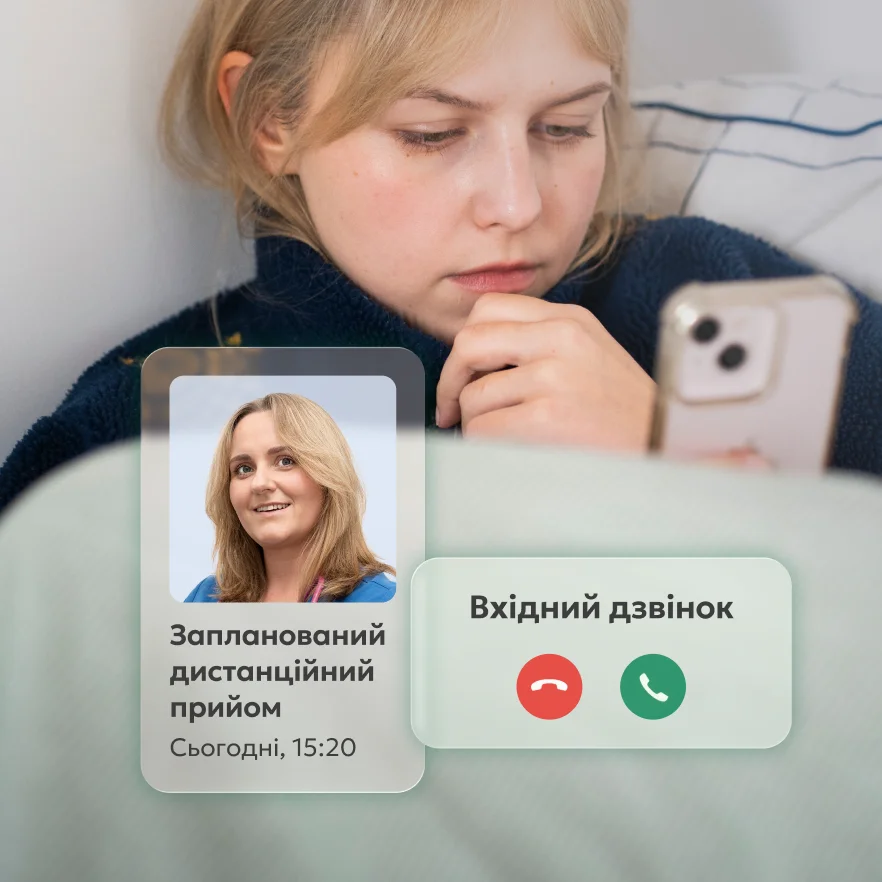 Жінка, яка лежить у ліжку і дивиться на екран телефону